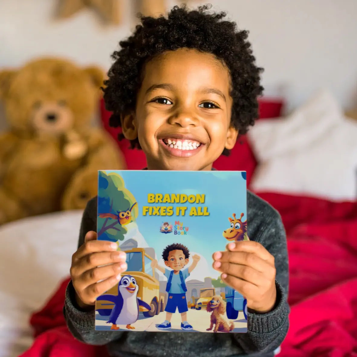 A smiling young child holding the personalized storybook with the title "Brandon Fixes It All," showcasing the product in use.